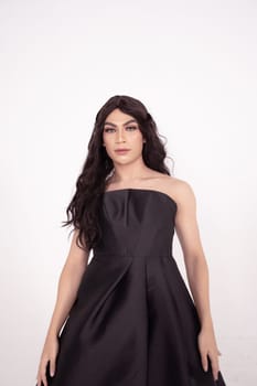 The wedding bride in black dress poses before the wedding ceremony in a white room