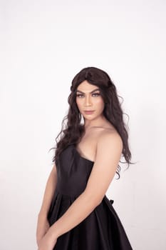Asian woman sadly holding her face with her hand while wearing a black dress with brown hair