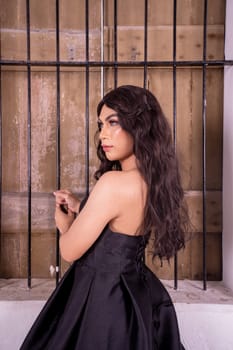 A beautiful Asian woman poses in front of the wooden windows in elegance face inside the white room