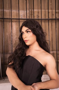Asian woman poses in front of the old rustic window while wearing a black dress in a white room