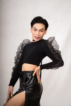 Beautiful Asian man wearing a black tank top with a happy face while in front of the white background