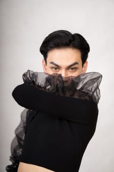The beautiful man had style in a black costume with black hair and a pretty face inside the white studio