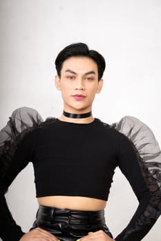 The beautiful man sitting on the chair while wearing a black costume with a pretty face inside the white studio