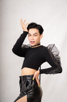 Beautiful Asian man wearing a black tank top with a happy face while in front of the white background