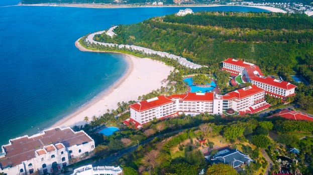 Luxury hotel at sea with sandy beach in island in Nha Trang in Vietnam, top aerial view. A resort for summer vacation