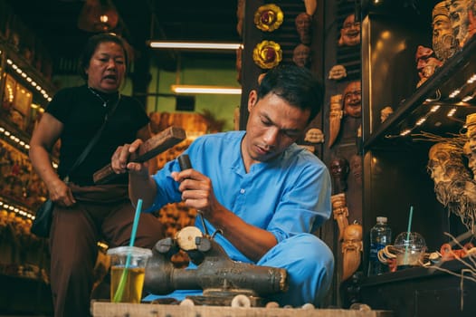 Asian male artisan craftsman carpenter works in wood carving workshop carpentry in old town in Hoi An city in Vietnam in Asia. Hoi An, Vietnam - December 1, 2024
