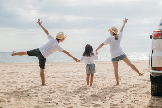 Happy family three is standing hand in hand on sandy beach, Parents father and mother holding hands their children back car, holiday vacations summer road trip, Family day enjoying their time together