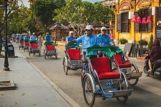 A traditional Asian transport is a bicycle rickshaw on the street of the old town in Hoi An city in Asia. Hoi An, Vietnam - December 1, 2024