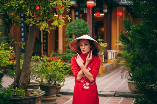 woman tourist traveler in Vietnamese cone hat Non la at Hoi An pagoda in Vietnam in Asia