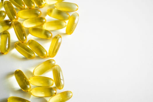 A high-key shot showing shiny yellow omega-3 capsules arranged with ample white space, ideal for health, diet, and wellness themes in editorial or commercial use.