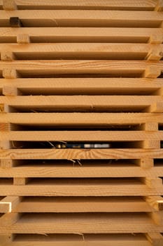 Neatly arranged pine wood planks stacked horizontally for drying in a lumber facility. Clean cuts and repetitive structure ideal for industrial design use.