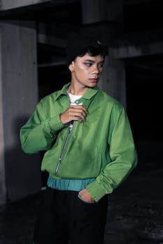 an Asian man is standing in an abandoned building in an eccentric outfit at night