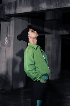 an Asian man wearing a green jacket and black beanie in an old building