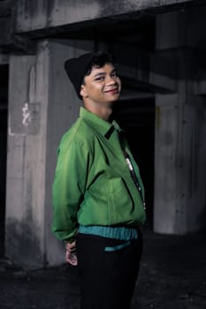an Asian man smiles while wearing a green parachute jacket and black pants at night
