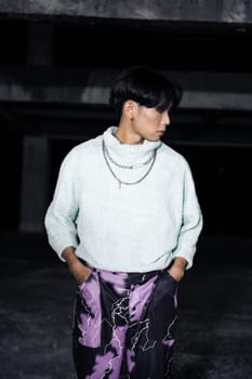 an asian man posing in a white sweater and a chain necklace around his neck in an old building