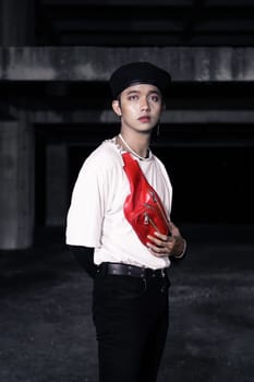 an Asian man standing in an old building with eccentric clothes at night