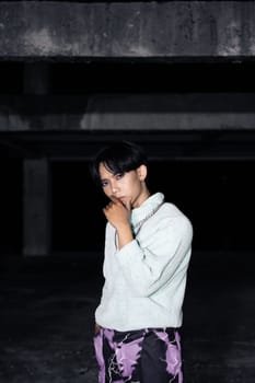 an asian man posing in a white sweater and a chain necklace around his neck in an old building