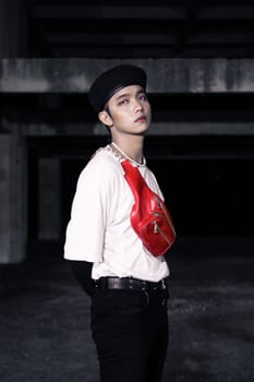 an Asian man standing in an old building with eccentric clothes at night