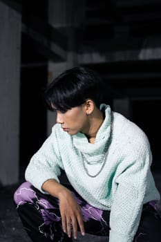 an asian man with black hair squats very masculine in an old building