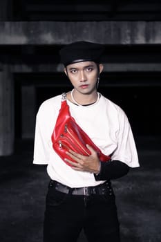 an Asian man standing in an old building with eccentric clothes at night