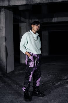 an asian man in black pants with a lightning pattern and a white sweater stands in a haunted building