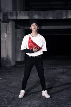 an Asian man standing in an old building with eccentric clothes at night