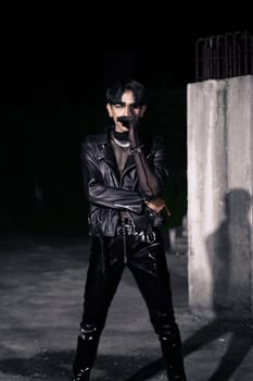 an asian man in a black leather jacket posing like a motorcycle gang in an old building