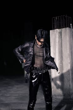 an asian man in a black leather jacket posing like a motorcycle gang in an old building