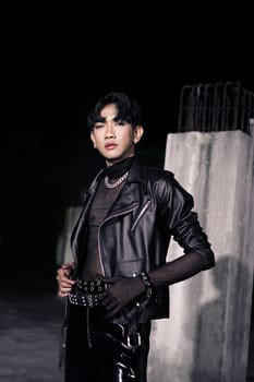 an asian man in a black leather jacket posing like a motorcycle gang in an old building