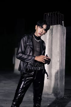 an asian man in a black leather jacket posing like a motorcycle gang in an old building