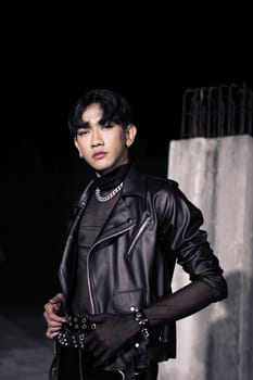 an asian man in a black leather jacket posing like a motorcycle gang in an old building