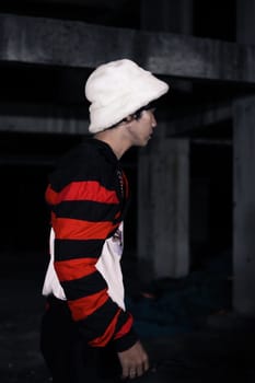 an Asian man is standing in a crimson outfit and a white hat in a haunted building