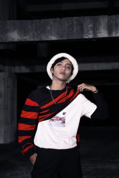 an Asian man is standing in a crimson outfit and a white hat in a haunted building