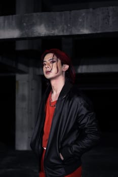 an asian man with red hair and a black jacket is posing in an abandoned building at night