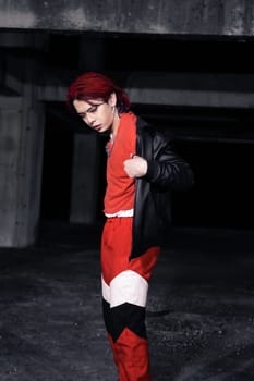 an asian man with red hair and a black jacket is posing in an abandoned building at night