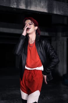 an asian man in a red shirt and earrings in his ears is standing in an abandoned building