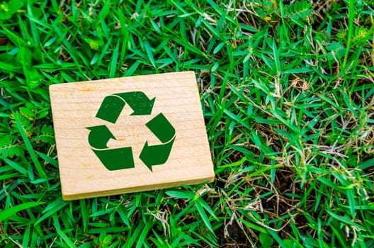 Top view of close up Recycle symbol on wooden block with customizable space for text. For a greener tomorrow concept.