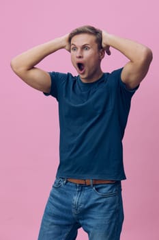shocked man surprised young caucasian male wearing casual blue tshirt standing hands on head open mouth isolated on pink background expressing amazement and mental health digital detox concept