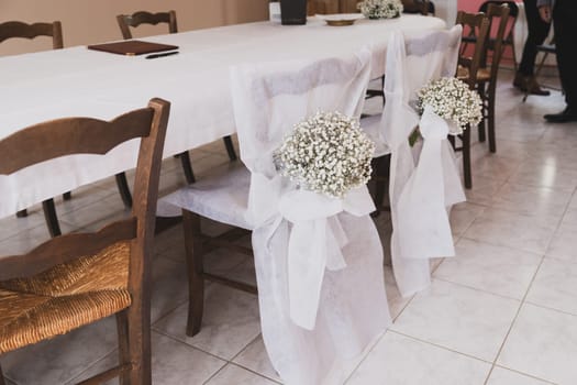 Wedding chairs decorated with white cloth and gypsophila flowers