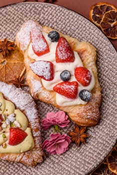 Food for breakfast sweet strawberry croissants with chocolate filling. French dessert, croissants with fruit and berries