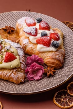 Food for breakfast sweet strawberry croissants with chocolate filling. French dessert, croissants with fruit and berries