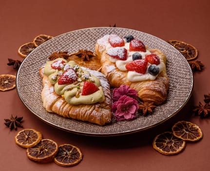Food for breakfast sweet strawberry croissants with chocolate filling. French dessert, croissants with fruit and berries