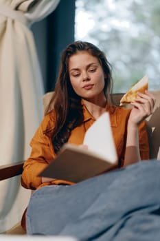 A young woman is absorbed in reading a book while enjoying a delicious sandwich, set in a cozy indoor space with soft natural light, ideal for promoting healthy eating and relaxation themes