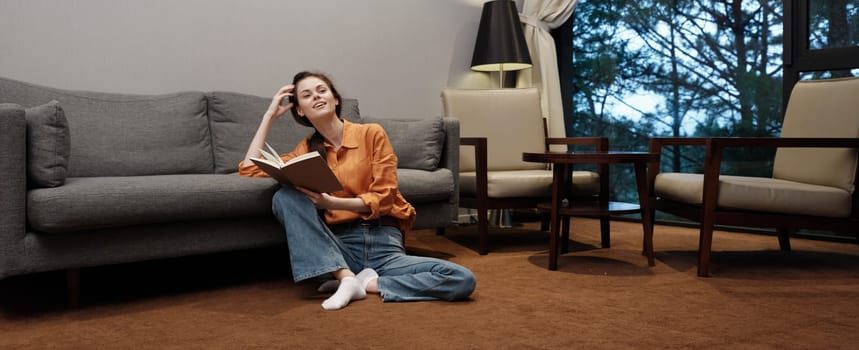 A relaxed young woman is enjoying a book in a warm, cozy living room The scene conveys tranquility and comfort with warm colors and soft lighting, ideal for wellness themes