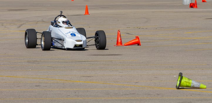 September 11, 2016 - Boise, Idaho:A race car is driving on a track with orange cones. The car is white and black and is in the middle of the track
