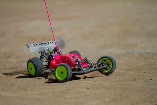 September 11, 2016 - Boise, Idaho: A red and green remote control car is on a dirt road. The car is moving and the camera is following it