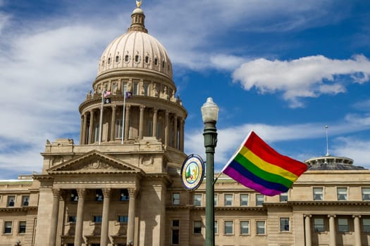 Jun 18, 2016 - Boise, Idaho:A gay pride flag is flying outside of the state capitol building. The flag is purple and white, and it is being held by a pole. The building is a large, historic structure