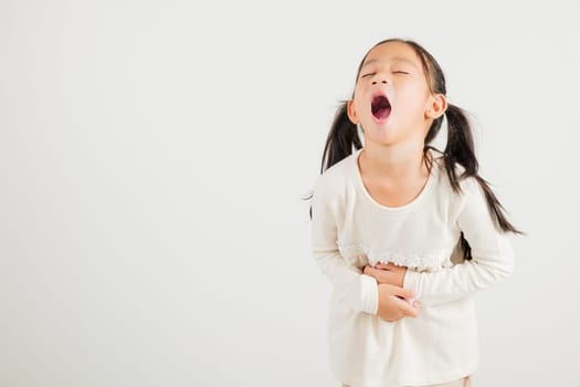 Portrait of Asian young kid girl has stomachache, kindergarten child abdominal pain suffering from stomach ache, studio shot isolated on white background, food poisoning, Health and medical gastritis