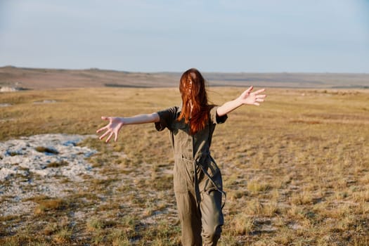 Freedom in the field expressive woman embracing nature and open space with outstretched arms in graceful pose