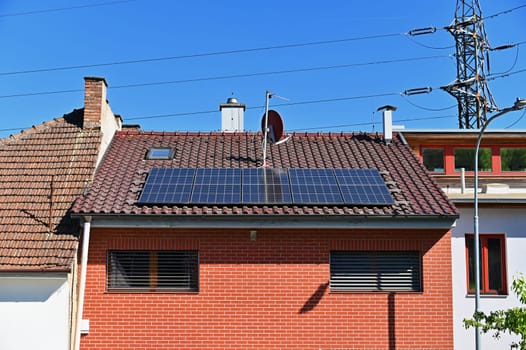 Family house with solar panels on the roof. Home photovoltaic power plant. Concept for industry and green cheaper electricity from renewable sources.
